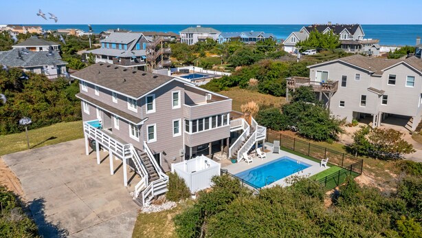 A residential area with houses, a swimming pool, and a view of the ocean. - Serenity Shores: 125ft. to Beach | Private Pool (Southern Shores)