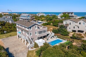 Uma área residencial com casas, piscina e vista para o oceano.