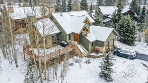 A snow-covered house with a stone staircase, a wooden deck, and a car parked in front. - Windflower Retreat: Beautiful Dog Friendly Home (Frisco)