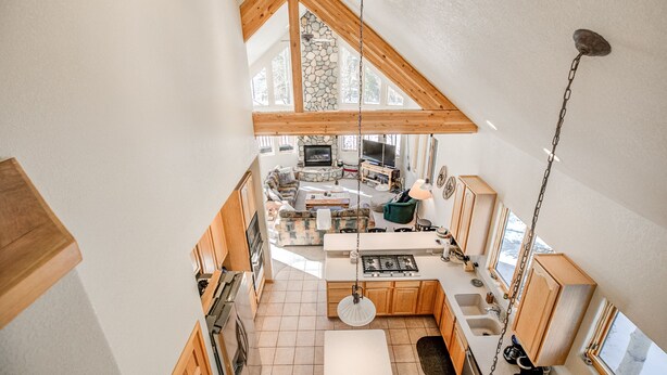 A spacious kitchen with high ceilings, wooden beams, and a stone wall. - Windflower Retreat: Beautiful Dog Friendly Home (Frisco)