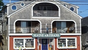 Un edificio de dos pisos con un letrero que dice 'MAINE ARTISANS'.