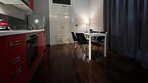 Une cuisine compacte dotée d’appareils électroménagers modernes et d’un coin repas avec une table et des chaises.