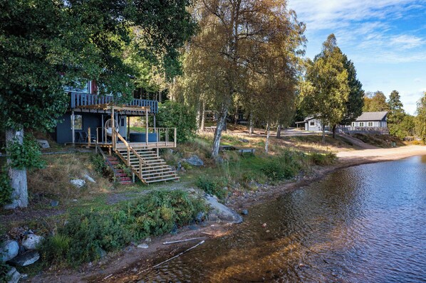 A riverside property with a wooden deck, a staircase, and a small building. - The beach - Bockaberg Private Resort & SPA (Floda)