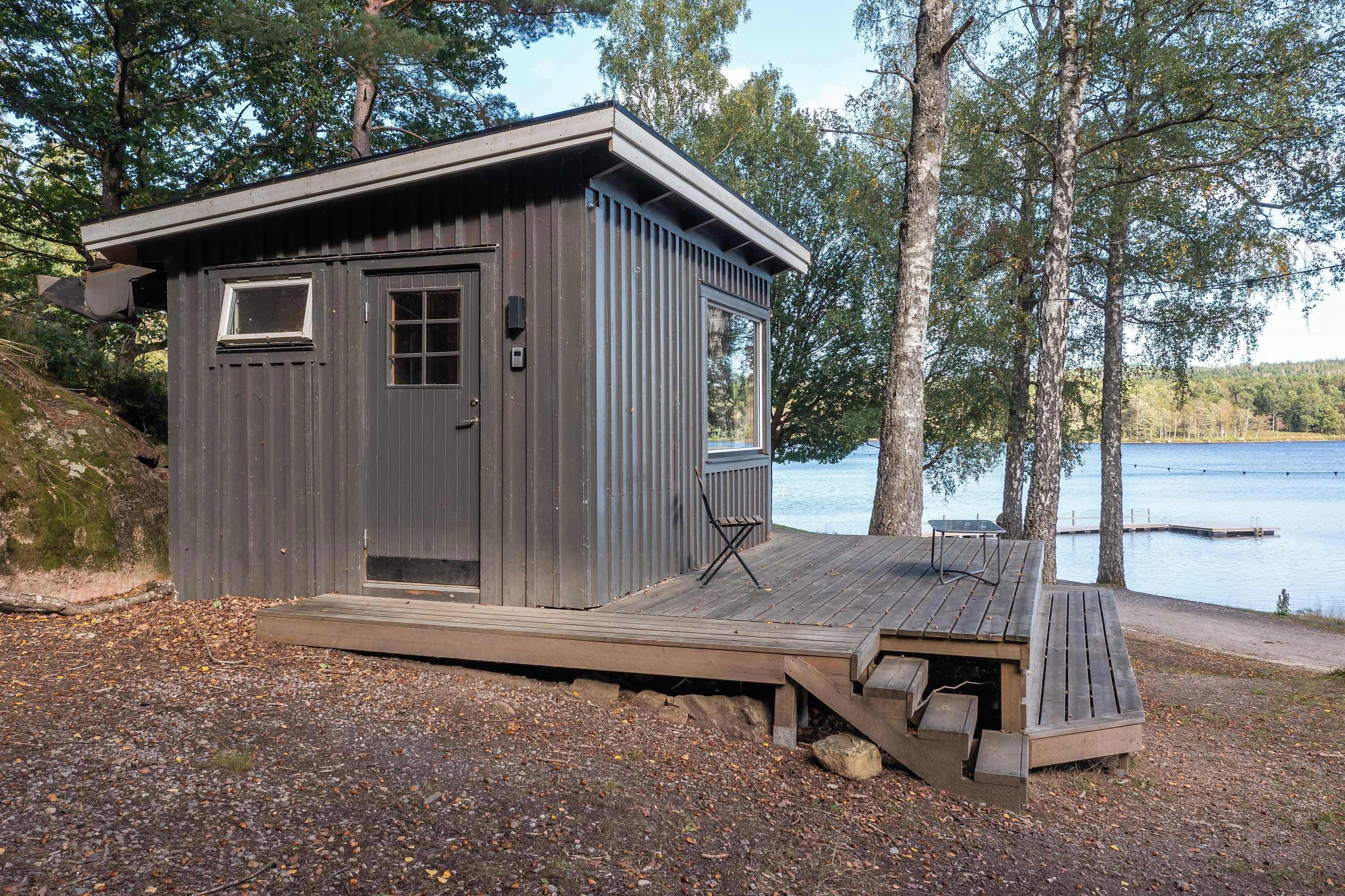 A small cabin with a deck, a door, and a window.