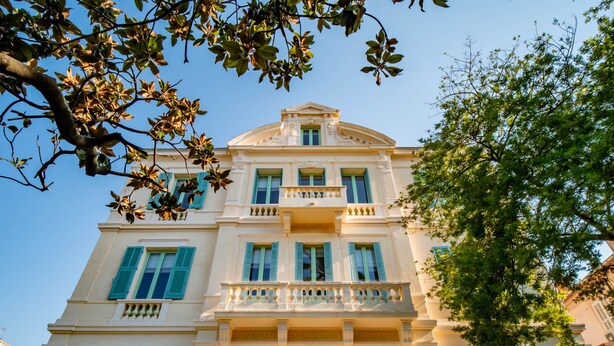 A multi-story building with a classical architectural style, featuring a central balcony with balustrades, multiple windows with shutters, and a symmetrical facade. - Banana's Camp - Hostel (Cannes)