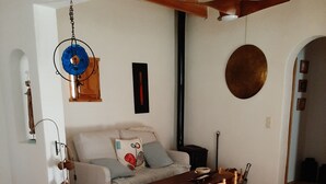 A living room with a sofa, a dining table with chairs, a ceiling fan, and a tiled floor. - House in a typical hamlet - Cabo de Gata Park (Carboneras)