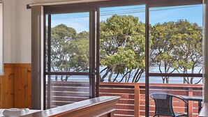 A room with a wooden desk and chair, a large window with a view of trees and a body of water. - Hook, Wine & Sinker Retreat (Stieglitz)