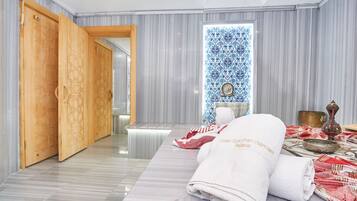 Experience a serene retreat with a large window, a comfortable bed, and a beautifully crafted door.
