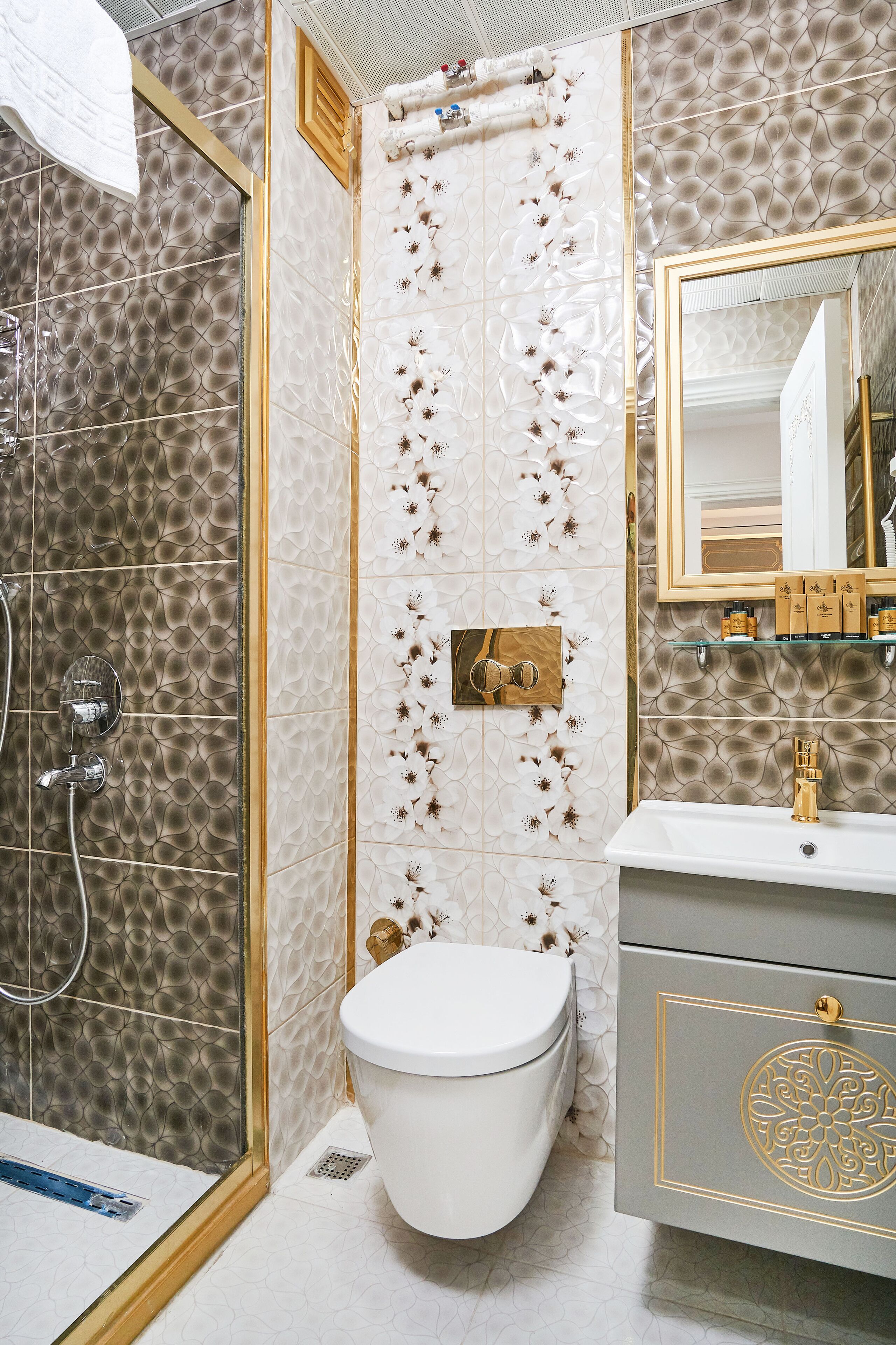A bathroom with a shower, toilet, and vanity with a mirror.