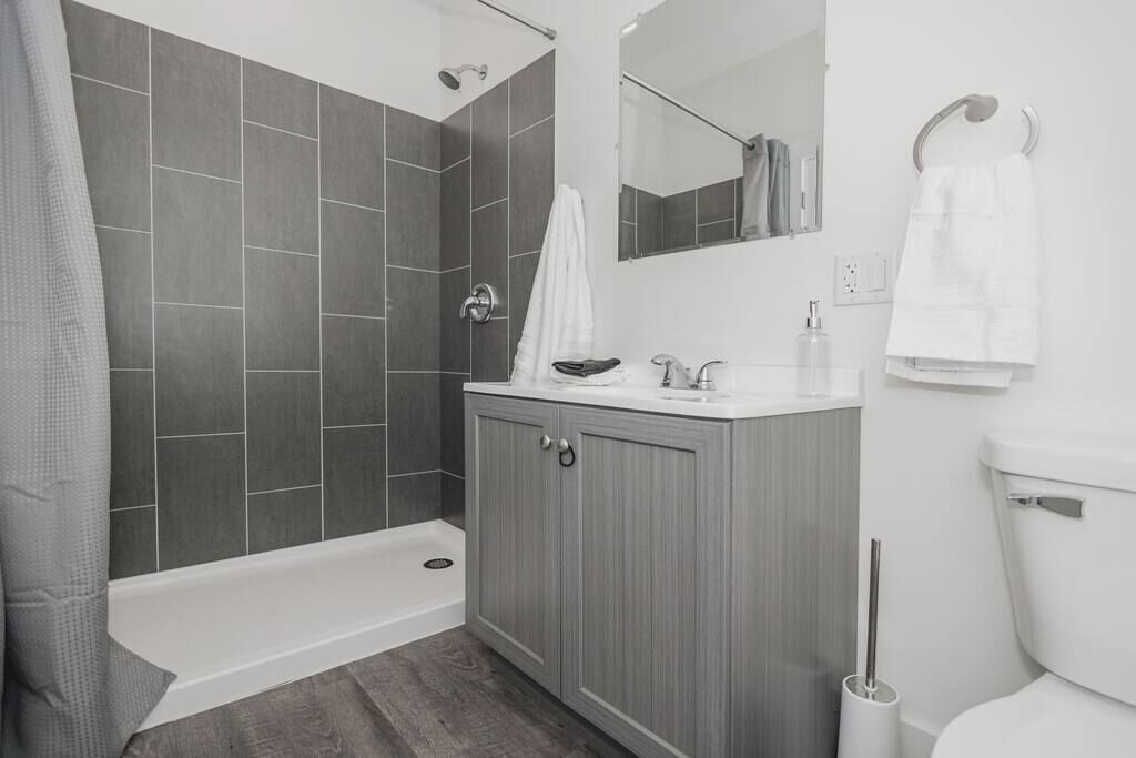 Un baño moderno con ducha, inodoro y tocador.