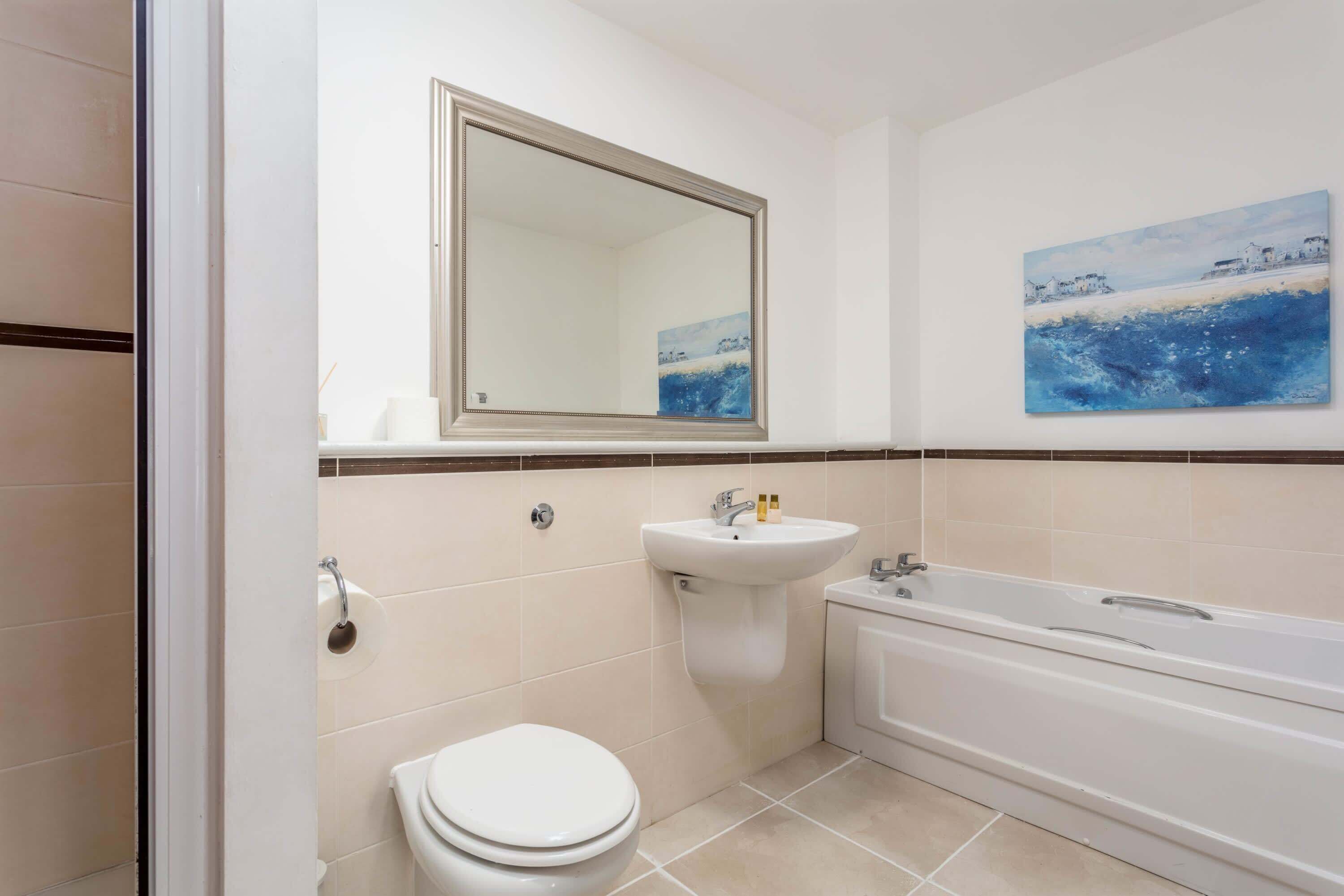 A bathroom with a toilet, sink, and bathtub.