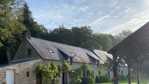 A stone building with a gravel driveway and a covered area. - Kerguestenen - Longère pour 12 avec piscine (Inguiniel)