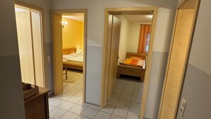 Una habitación de hotel con suelo de baldosas, una cama, un escritorio y un armario.