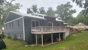 Ein zweistöckiges Haus mit einer Veranda und einem umzäunten Garten.
