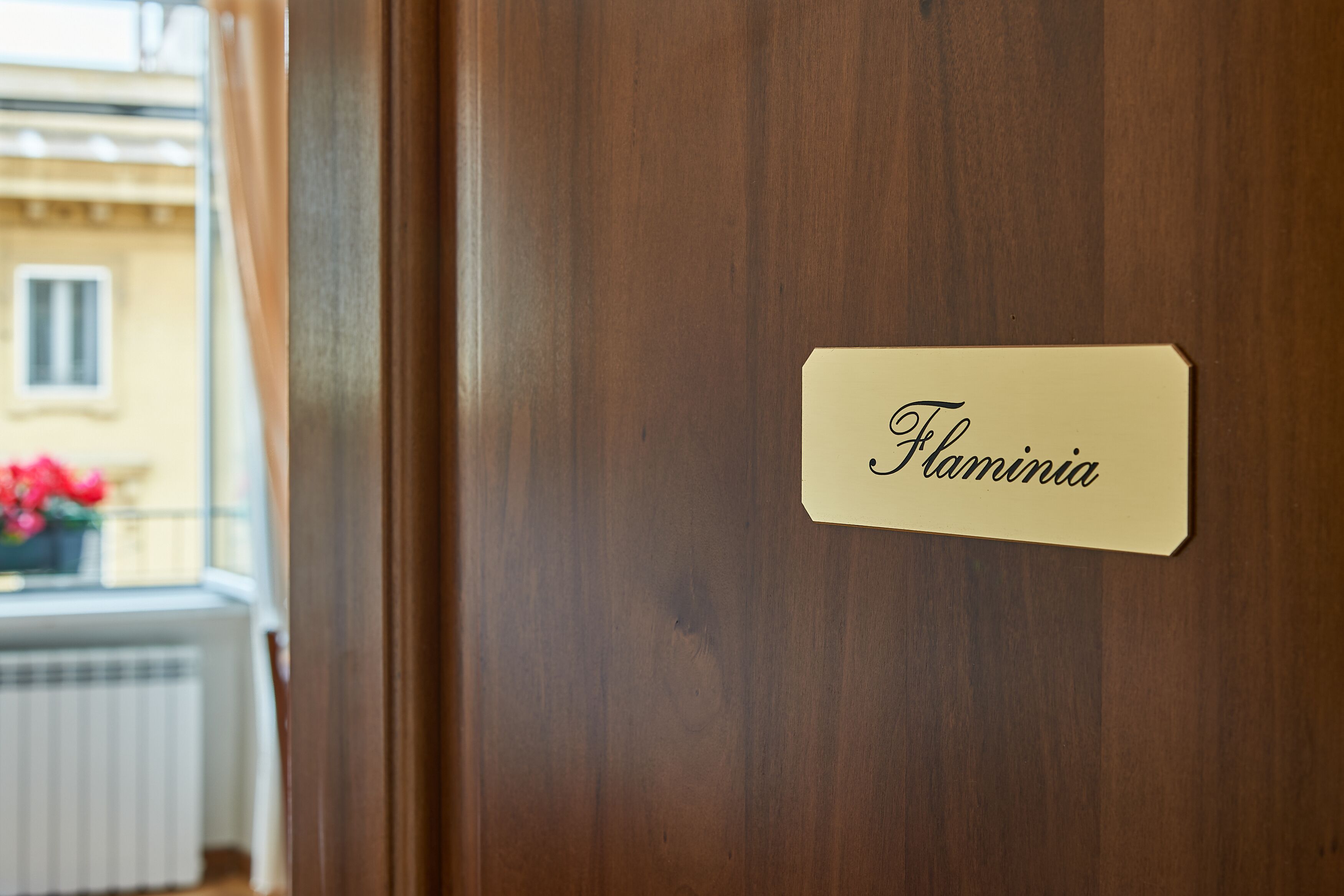 En dörr av trä med en namnskylt där det står ”Flaminia”.