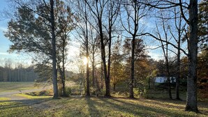 A paved area with trees and grass, a clear sky, and a distant house. - Cozy 1BR Apt Minutes From Skyline Drive!! (Amissville)
