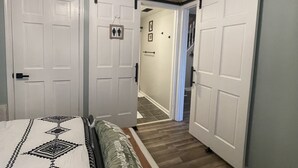 A bedroom with a bed, a ceiling fan, and a hallway leading to another room. - Cozy 1BR Apt Minutes From Skyline Drive!! (Amissville)