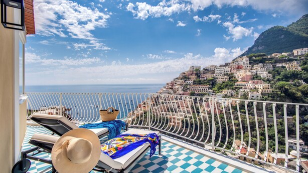 A balcony with sun loungers, a hat, and a checkered floor. - Palazzo Vittoria with wonderful terrace & Jacuzzi (Campania)