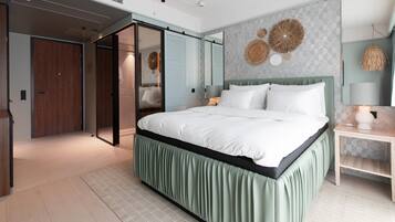 A modern bedroom with a large bed, a sliding door closet, and a wall-mounted mirror.