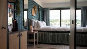 Una camera da letto moderna con un letto, un comodino e vista sulla città.