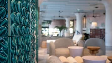 Un interior moderno con una pared texturizada color turquesa, asientos cómodos y una zona de bar.