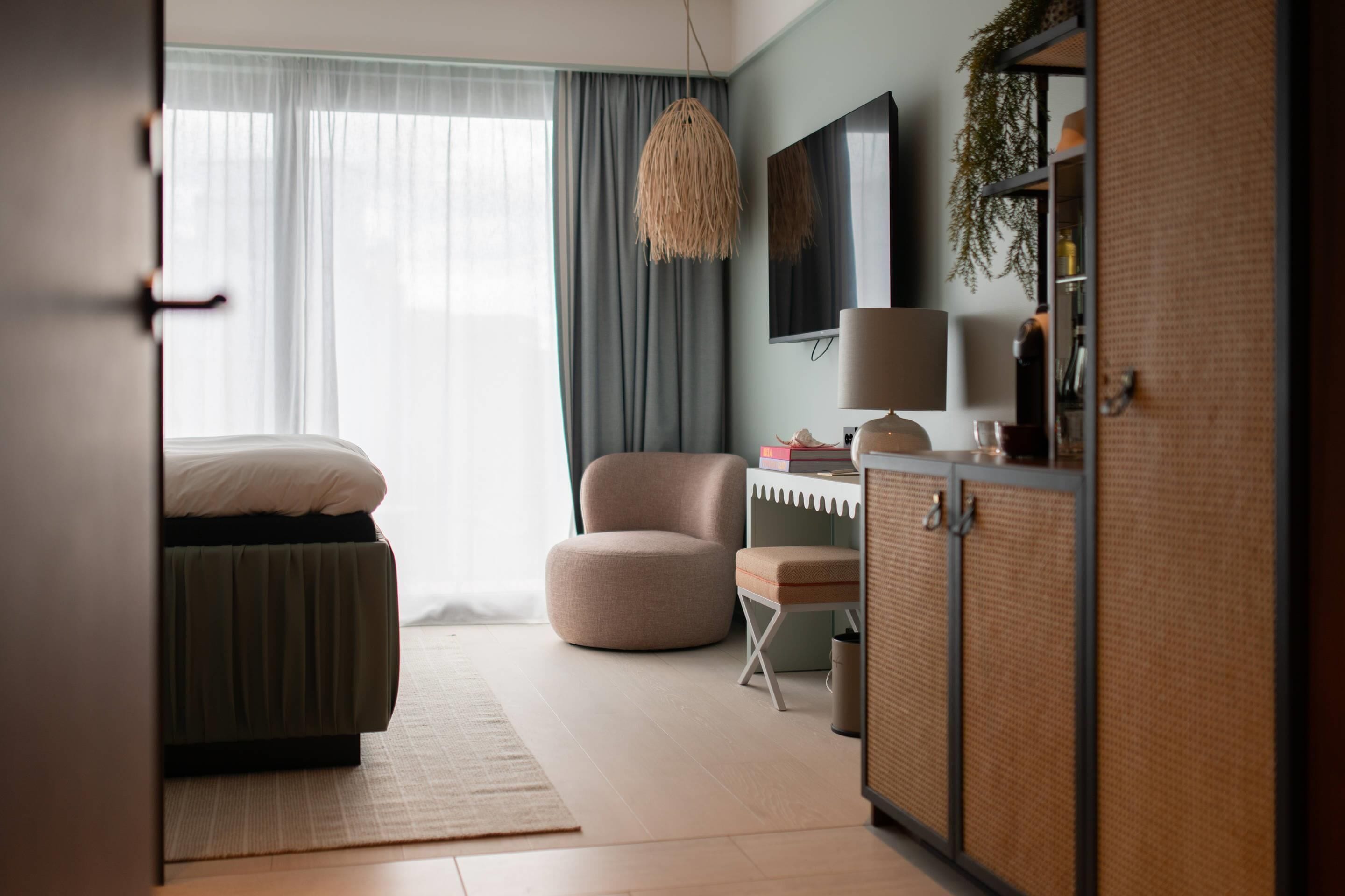 Une chambre à coucher comprenant un lit, un bureau, une chaise, une télévision et une armoire.