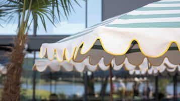 An outdoor seating area with wicker furniture and a striped umbrella.