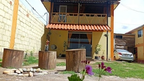 Una casa de dos pisos con techo de tejas rojas, un balcón y un garaje.