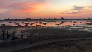 A calm water body with boats, a stone wall, and a wooden dock. - Spacious Refurbished Apartment - 2 mins walk from Bosham Harbour (Bosham)