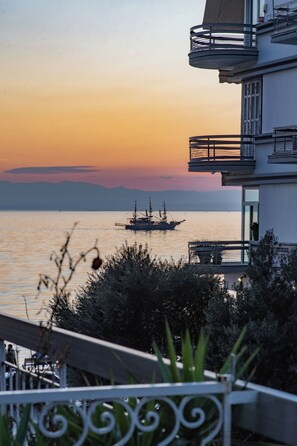 A coastal building with balconies overlooking a calm sea at sunset. - Houseloft Koromila Sea View (Thessaloniki)