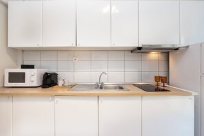 Een koelkast, een oven, een kookplaat, een koffiezetapparaat/waterkoker