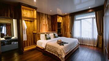 A large bed with a wooden headboard, a bedside table, and a mirror.
