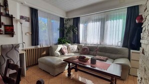 A living room with a sofa, a coffee table, a desk, and a radiator.