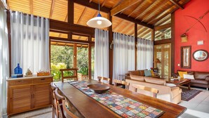 Amplia sala de estar con una mesa de comedor de madera, un sofá y una pared de acento roja.