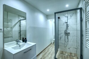 Bathtub, hair dryer, shampoo, toilet paper