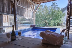 A wooden deck with a hot tub, towels, and a bottle of wine. - So Villa Chasseuserie (89) - Heated pool - Foot - 2h Paris - 45p. (Auxerre)