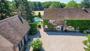 A courtyard with a swimming pool, stone buildings, and a gravel path. - So Villa Chasseuserie (89) - Heated pool - Foot - 2h Paris - 45p. (Auxerre)