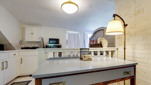A kitchen with white cabinets, a microwave, a stove, and a table with a lamp. - On-Site Pond: Spacious Family Home in Jefferson! (Jefferson)