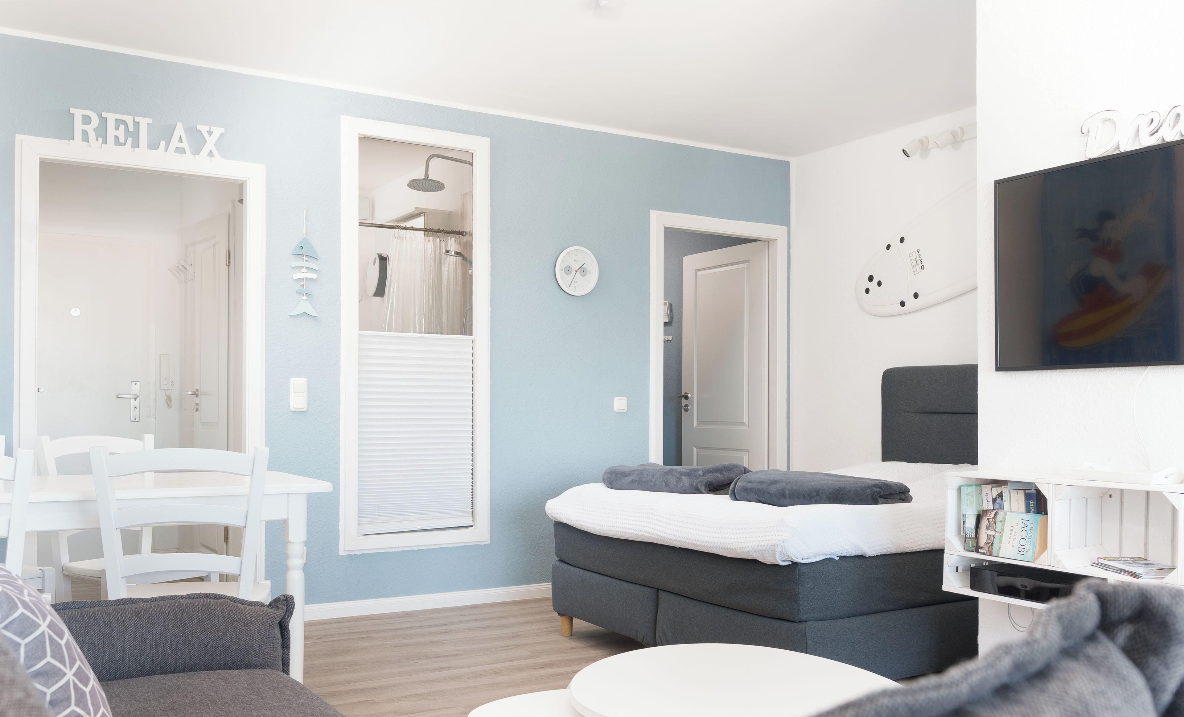 A modern bedroom with a bed, a small table, and a seating area.