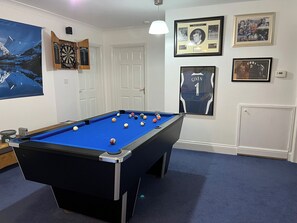 A pool table with balls, a dartboard, framed pictures, and a door. - 2 bedroom accommodation in Blaydon Burn, near Newcastle upon Tyne (Blaydon Burn, near Newcastle upon Tyne)