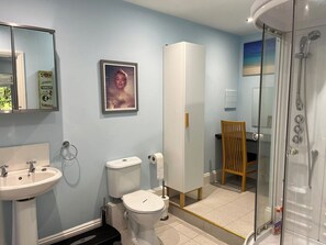 A bathroom with a sink, toilet, shower, and a framed picture on the wall. - 2 bedroom accommodation in Blaydon Burn, near Newcastle upon Tyne (Blaydon Burn, near Newcastle upon Tyne)