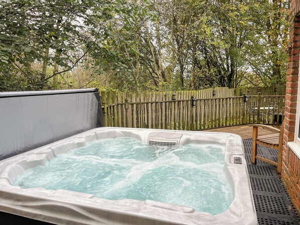 A hot tub with a wooden fence and trees in the background. - 2 bedroom accommodation in Blaydon Burn, near Newcastle upon Tyne (Blaydon Burn, near Newcastle upon Tyne)