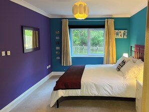 A bedroom with a bed, a window with curtains, a painting, and a ceiling light fixture. - 2 bedroom accommodation in Blaydon Burn, near Newcastle upon Tyne (Blaydon Burn, near Newcastle upon Tyne)