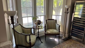 A room with two chairs, a table with a globe, and a lamp. - Independence Inn (Strafford)