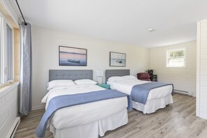 Une chambre d’hôtel avec deux lits, une fenêtre et une vue sur la mer.