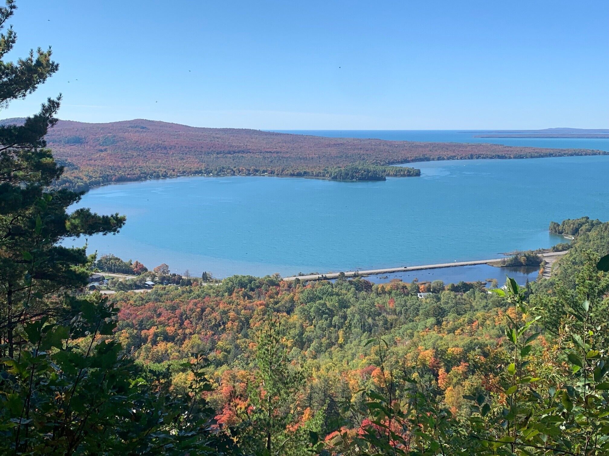 A panoramic view of a lake surrounded by forested hills.