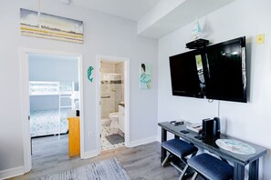2 habitaciones, escritorio y tabla de planchar con plancha