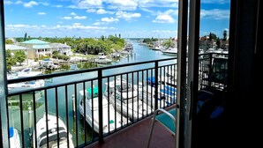 A balcony with a view of a marina and a river. - Waterfront Escape· Steps to Beach · Marina View (Madeira Beach)