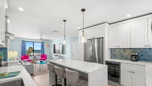 Una cocina moderna con una isla central, electrodomésticos de acero inoxidable y un diseño luminoso y espacioso.