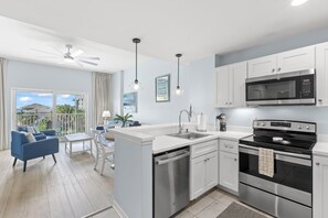 A modern kitchen with white cabinetry, a microwave, an oven, and a dishwasher. - Coastal Retreat in Madeira Beach/Johns Pass (Madeira Beach)
